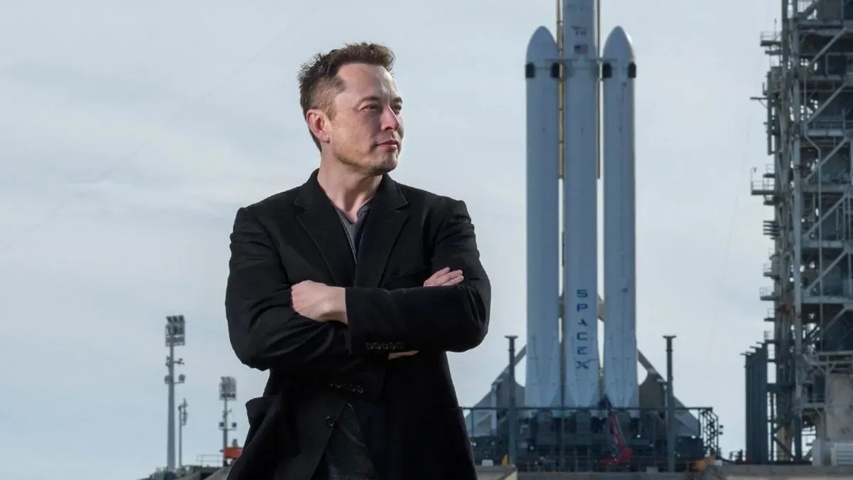 Elon Musk in front of a SpaceX Falcon Heavy rocket